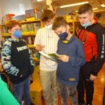 Junge Burschen rätseln in der Bücherei